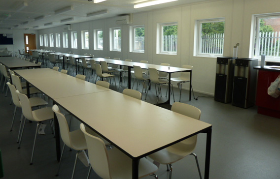 Inside a modular building classroom showing desks and chairs